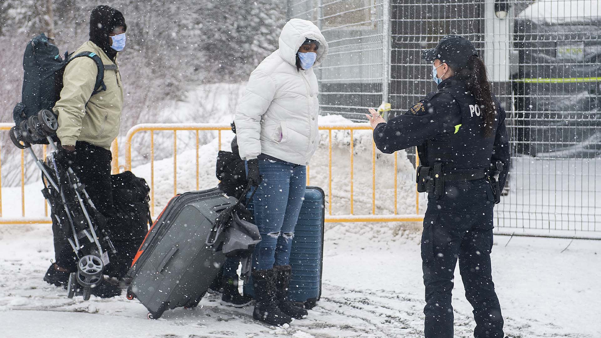 Une agent de la GRC arrête des personnes qui entrent au Canada par la route de Roxham à la frontière canado-américaine à Hemmingford, au Québec, le 25 mars 2023.
