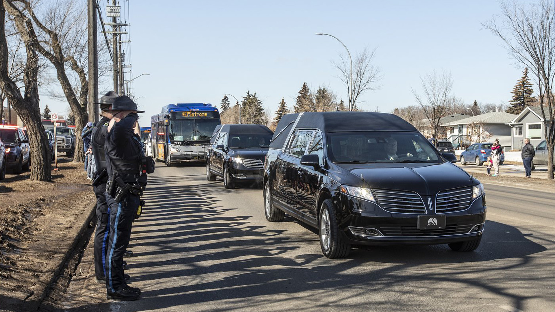 Salut de la police lors d'une procession vers un salon funéraire pour Const. Travis Jordan et Const. Brett Ryan à Edmonton le mardi 21 mars 2023. Des funérailles régimentaires doivent avoir lieu lundi pour les deux officiers, qui ont été tués par balle alors qu'ils répondaient à un différend familial.