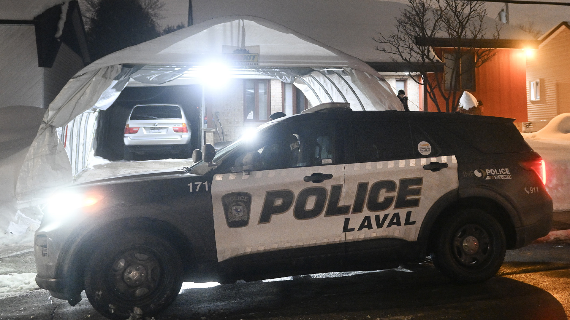 Des policiers sont montrés devant la maison de Pierre Ny St-Amand à Laval, au Québec, le mercredi 8 février 2023.