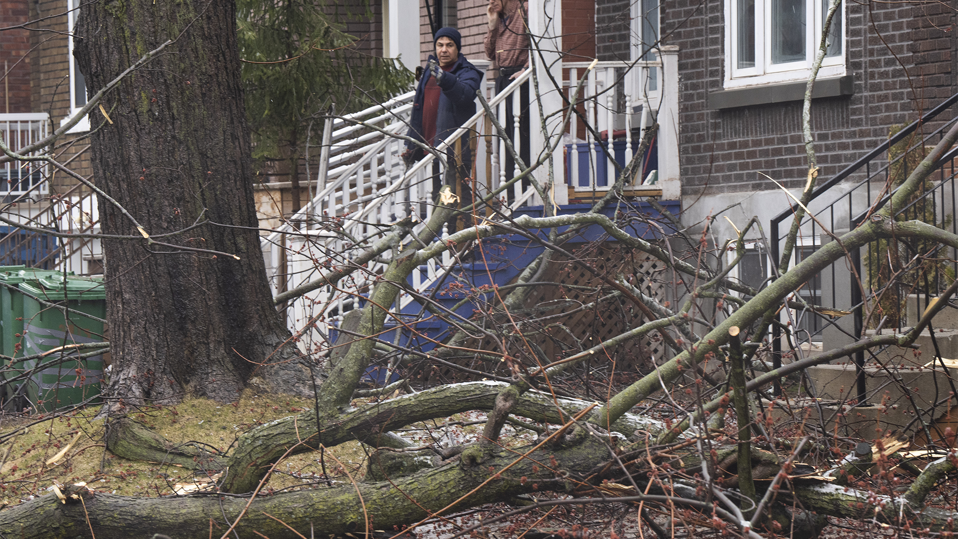 Des gens surveillent les dégâts sur leur domicile à Montréal, le jeudi 6 avril 2023 après une tempête de verglas qui a laissé plus d'un million de clients sans électricité dans la province.