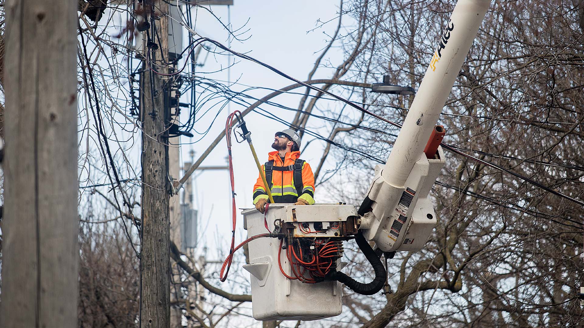 Un travailleur d'Hydro travaille une ligne électrique à la suite de la tempête de verglas à Montréal, le 7 avril 2023.