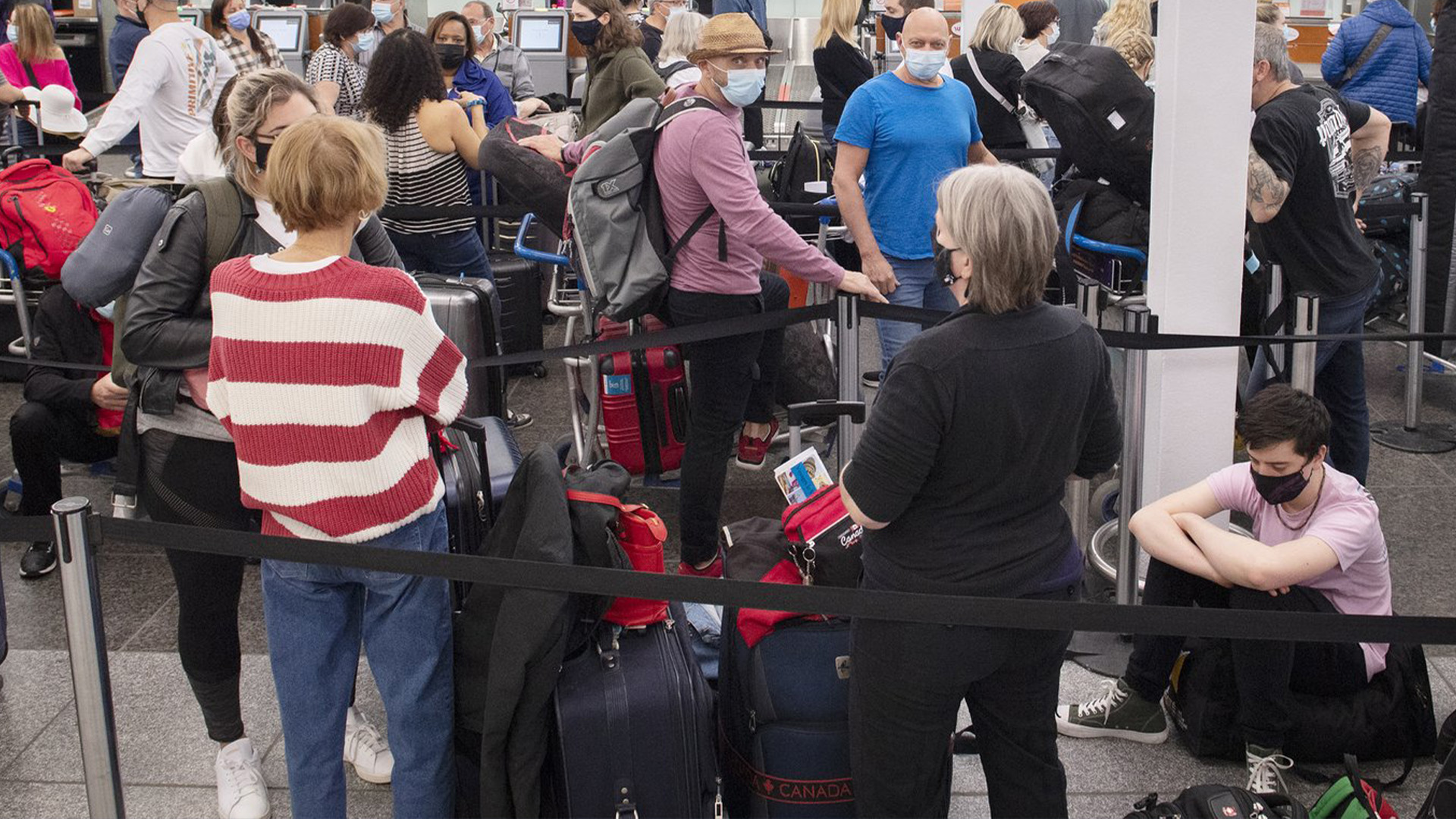 Les voyageurs font la queue à un comptoir d'enregistrement à l'aéroport Trudeau de Montréal, le mercredi 20 avril 2022. Les aéroports et les compagnies aériennes canadiennes ont enregistré un grand nombre de retards de vol le mois dernier, ce qui soulève des questions sur leur état de préparation pour la ruée vers les voyages d'été.