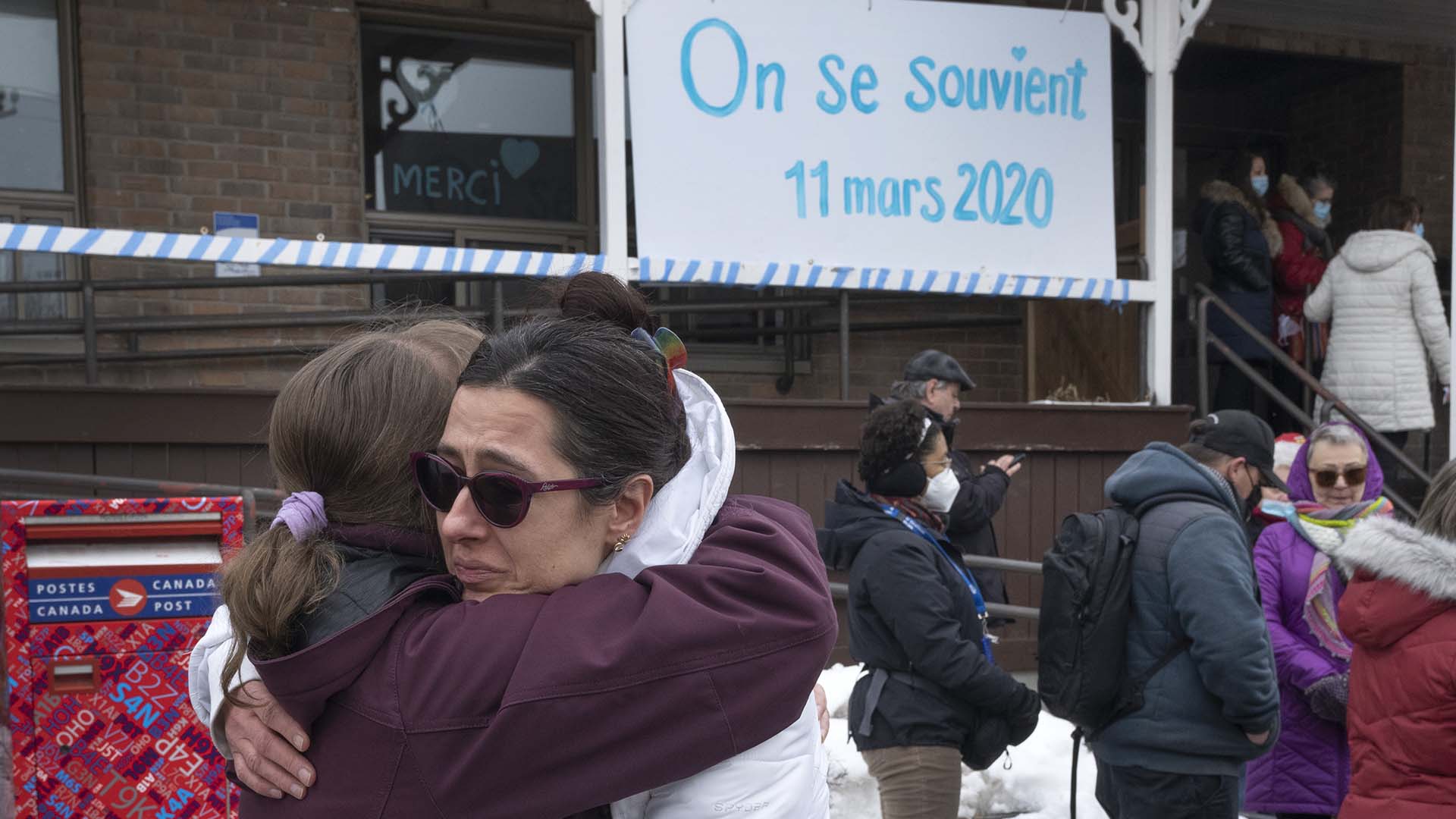 Des femmes s'enlacent le jour du deuxième anniversaire de la déclaration de pandémie, en mars 2022 à Montréal.