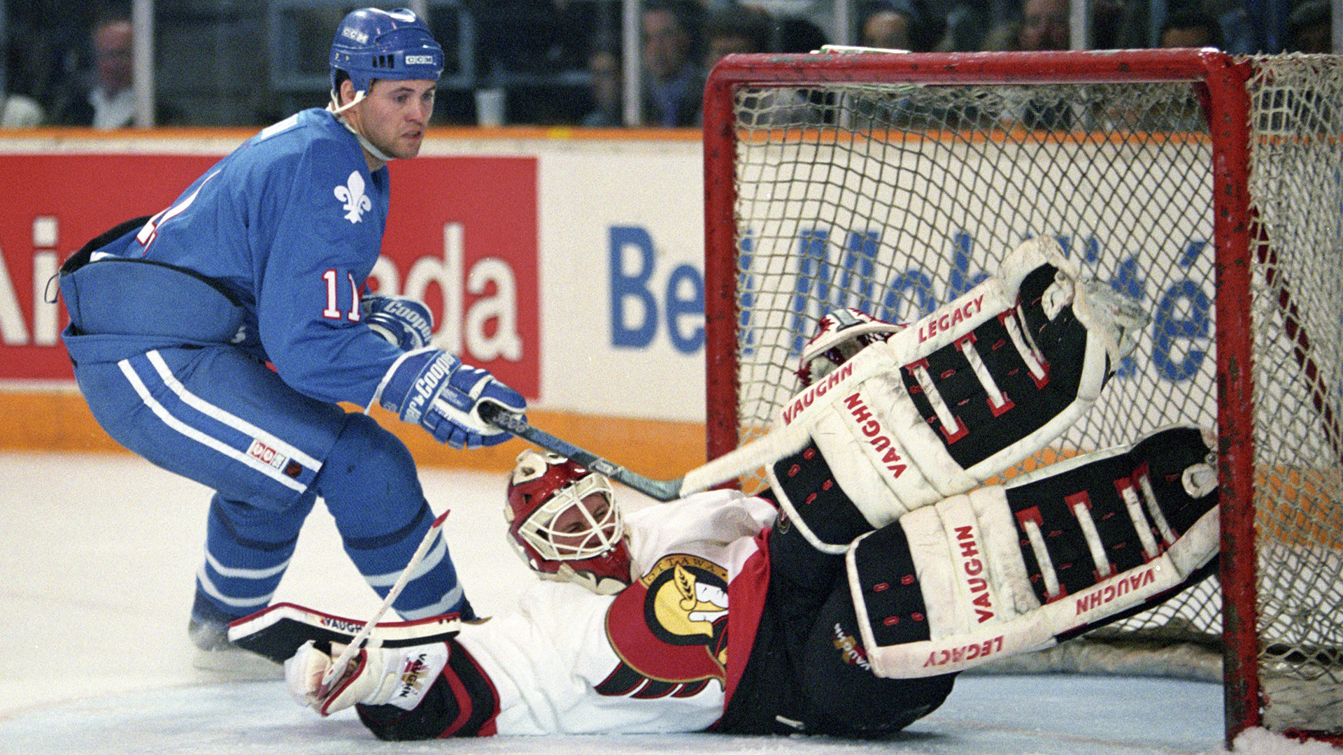 Le gardien des Sénateurs d'Ottawa, Craig Billington, effectue un arrêt sur le joueur des Nordiques de Québec, Owen Nolan, lors de la première période d'un match de la LNH à Ottawa le 6 octobre 1993.