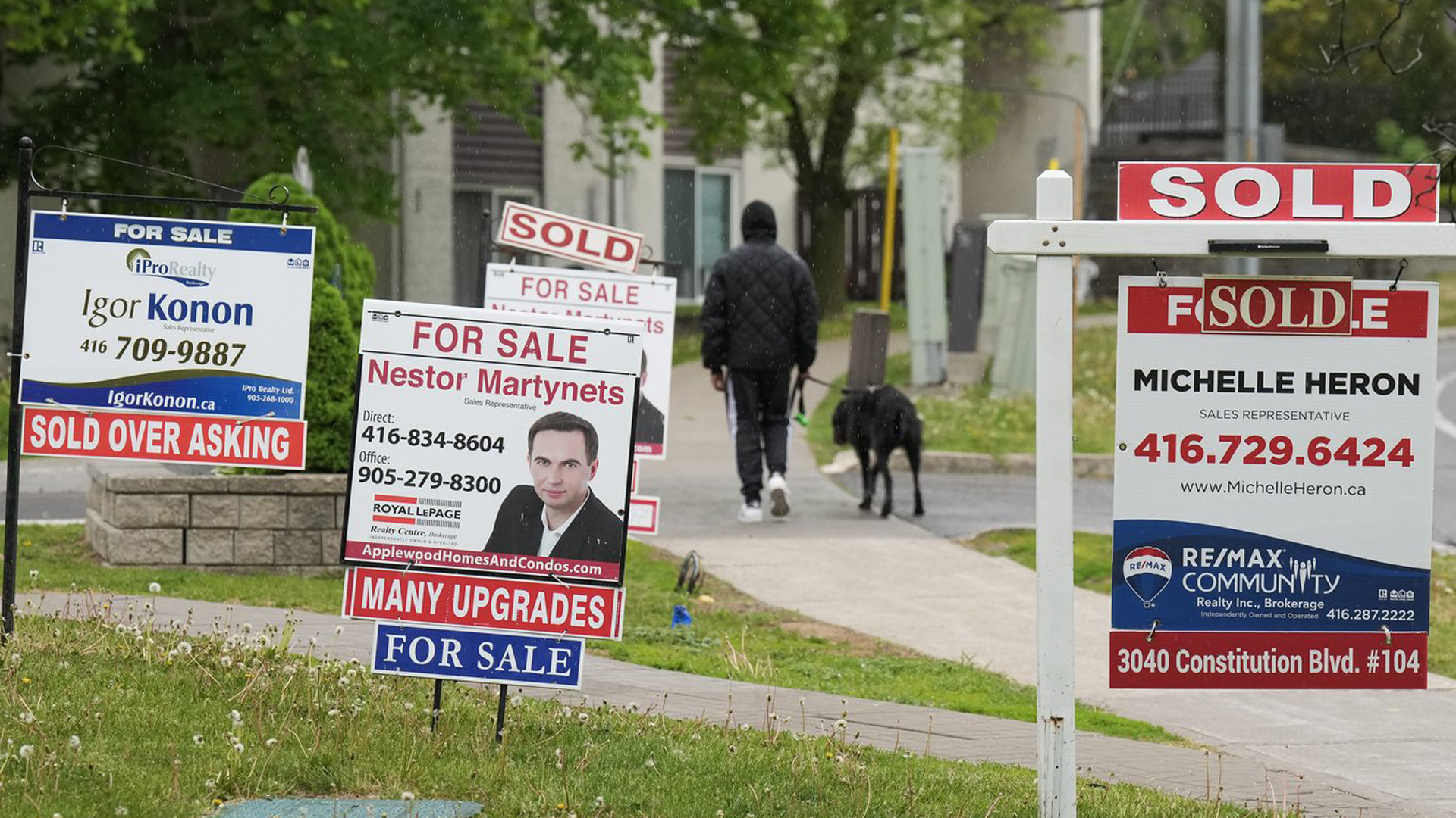 La Société canadienne d'hypothèques et de logement affirme que la dette hypothécaire résidentielle du pays a augmenté de 6 % par rapport à l'année dernière pour atteindre 2,08 billions de dollars. Une personne passe devant plusieurs enseignes immobilières à vendre et à vendre à Mississauga, en Ontario, le mercredi 24 mai 2023.