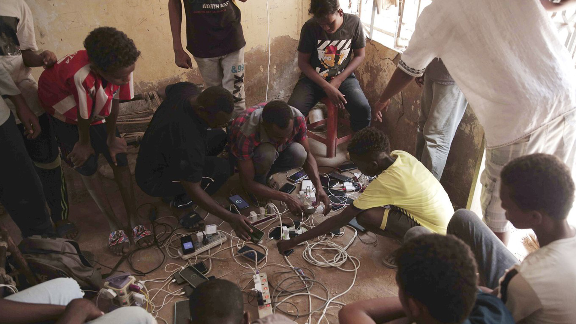 Les gens se rassemblent au domicile d'un volontaire, où ils peuvent recharger leurs téléphones portables, à Khartoum, au Soudan, le jeudi 25 mai 2023.