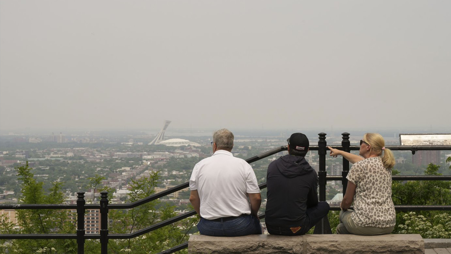 Un groupe de touristes regarde vers l'est depuis un belvédère sur le mont Royal le lundi 5 juin 2023. Un avertissement de smog est en vigueur pour Montréal et plusieurs régions de la province en raison d'incendies de forêt.