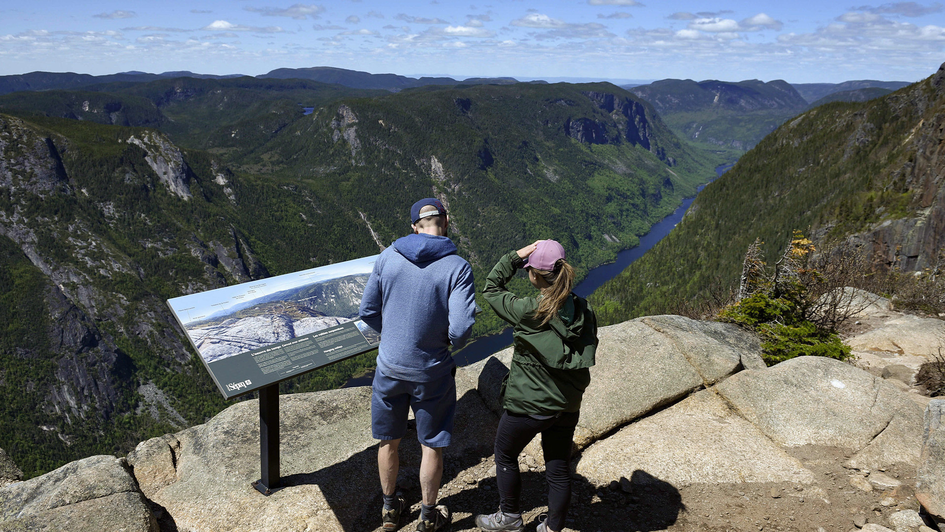 Des randonneurs admirent la vue depuis un belvédère lors d'une randonnée dans le parc national des Hautes Gorges de la Rivière Malbaie, un parc provincial de la région de Charlevoix au Québec, le dimanche 10 juin 2018.