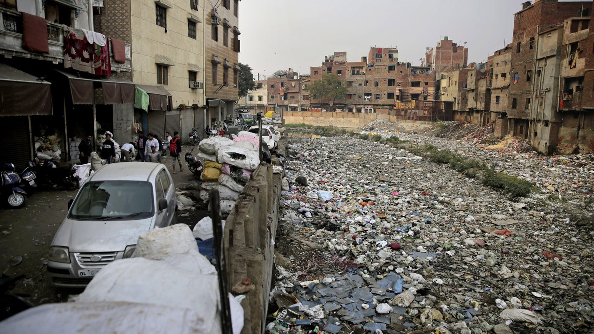 En ce samedi 8 décembre 2018, des piles de photos de déchets électroniques sont placées à côté d'un drain rempli de plastique et d'ordures à New Delhi, en Inde.