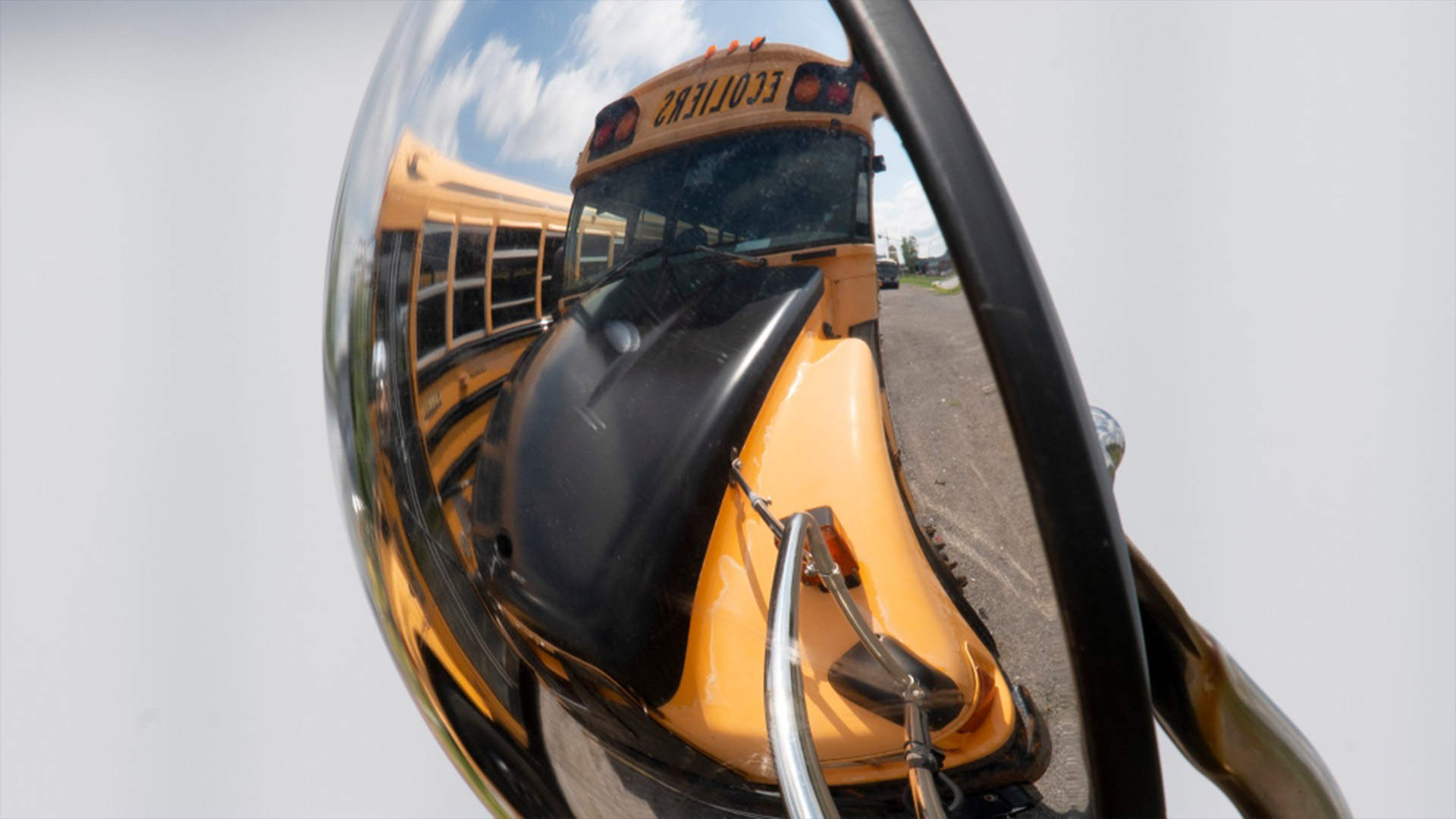Un autobus scolaire du Québec se reflète dans l'un de ses miroirs dans un stationnement le lundi 10 août 2020 à Gatineau, au Québec.