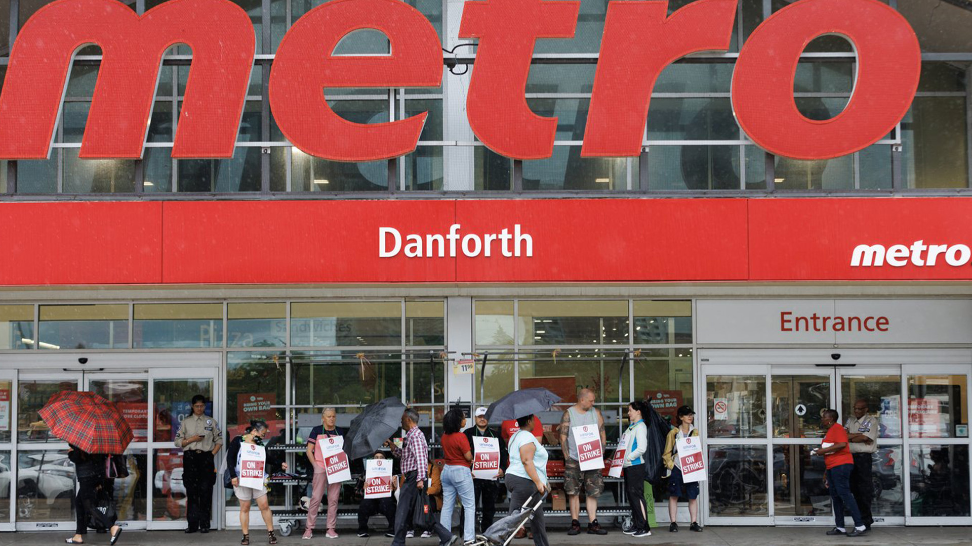 Les travailleurs de Metro de 27 magasins de la région du Grand Toronto votent aujourd'hui sur un deuxième accord de principe qui, s'il est ratifié, mettra fin à une grève de plus d'un mois. Des clients, des travailleurs et des agents de sécurité se tiennent devant une épicerie Metro à Toronto, le samedi 29 juillet 2023.