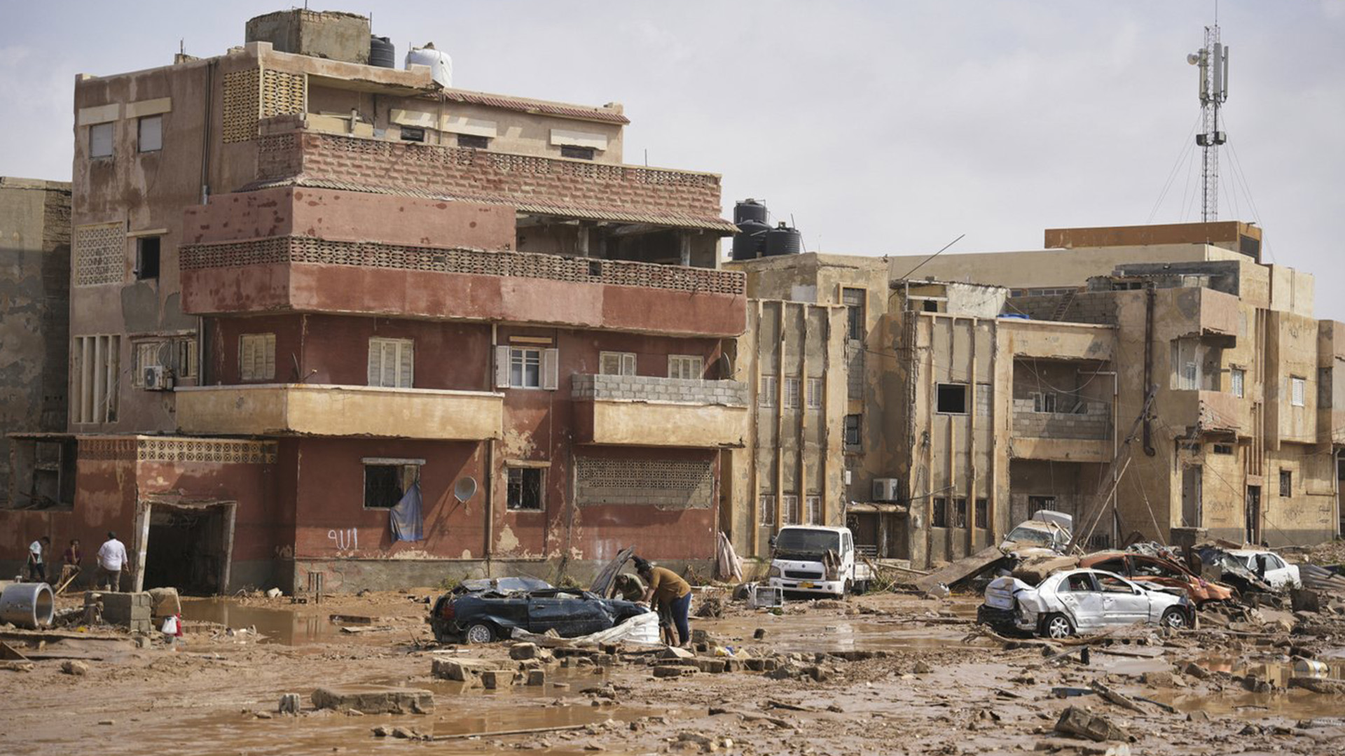 Sur cette photo fournie par le gouvernement libyen, des voitures et des décombres gisent dans une rue de Derna, en Libye, le lundi 11 septembre 2023, après que la rue ait été inondée par de fortes pluies.