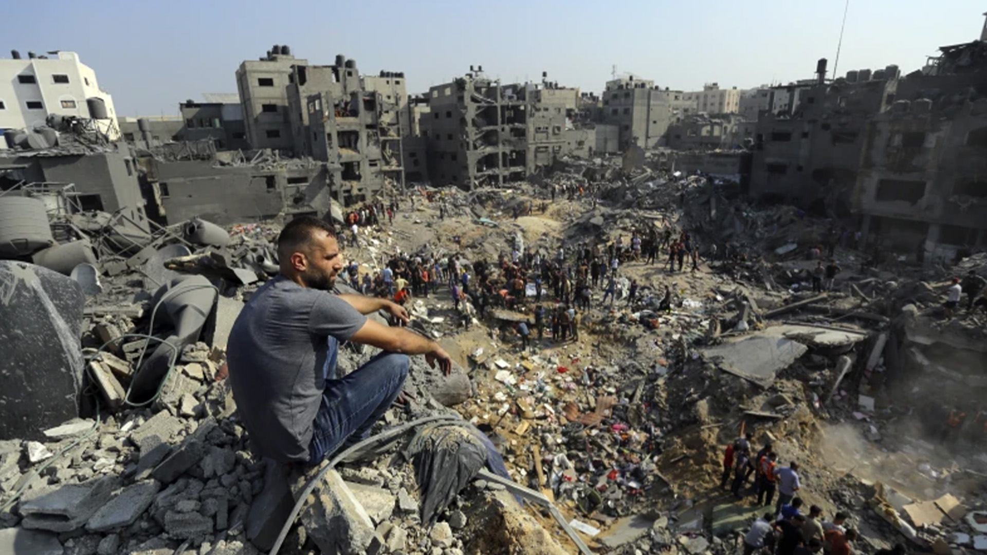 Un homme est assis sur les décombres tandis que d’autres errent parmi les débris de bâtiments ciblés par les frappes aériennes israéliennes dans le camp de réfugiés de Jabaliya, au nord de la bande de Gaza, le mercredi 1er novembre 2023.