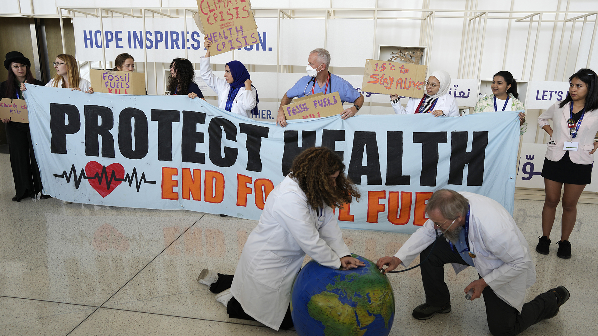 Des activistes font semblant de ressusciter la Terre lors d'une manifestation au sommet climatique de l'ONU COP28, le 6 décembre 2023, à Dubaï.
