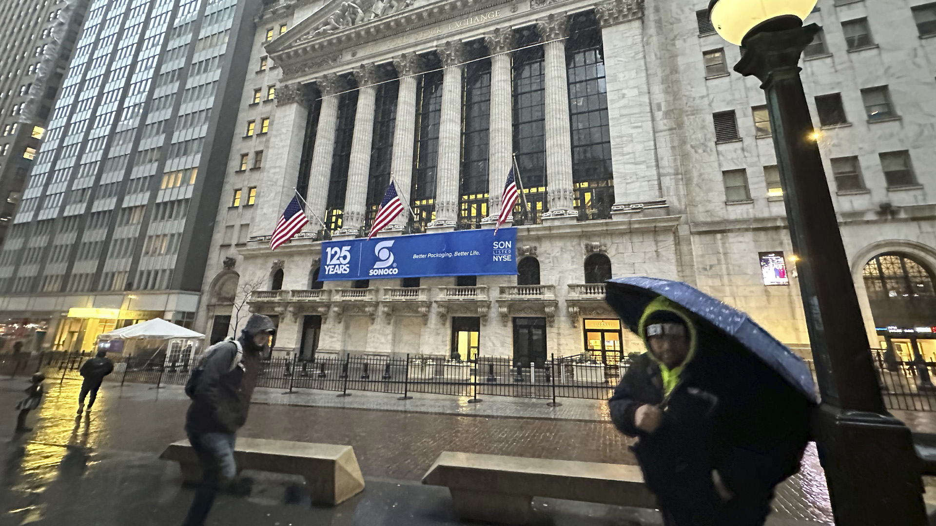 Des piétons passent devant la Bourse de New York alors que la neige tombe le mardi 13 février 2024 à New York. 