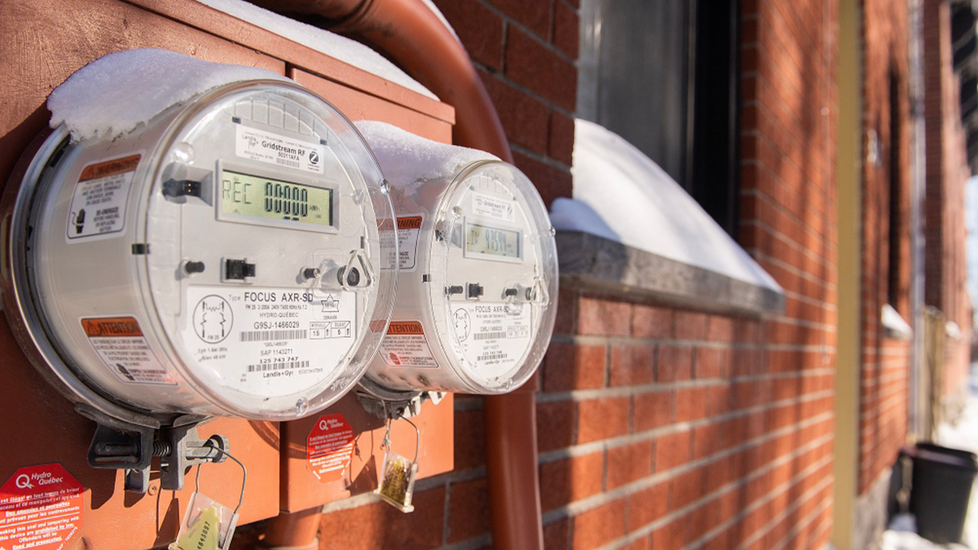 Des compteurs d'électricité sont visibles sur le côté des maisons à Montréal, le samedi 4 février 2023.
