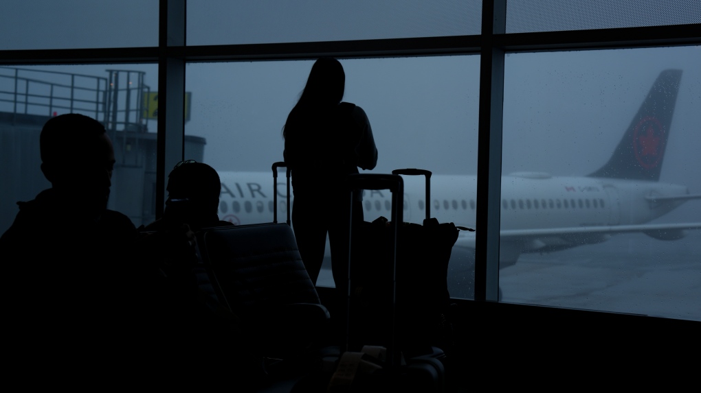 Des passagers attendent de monter à bord d'un vol à l'aéroport d'Halifax, le mercredi 27 mars 2024. 