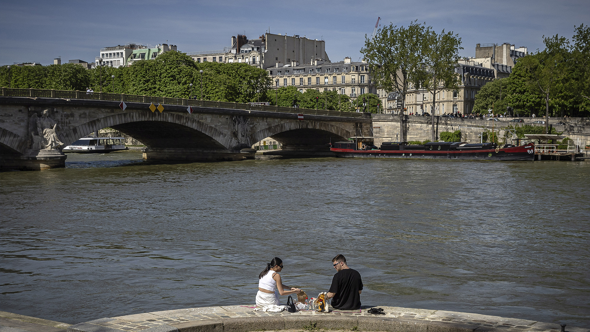 Un couple profite d'une pause au bord de la Seine, le samedi 13 avril 2024 à Paris. 