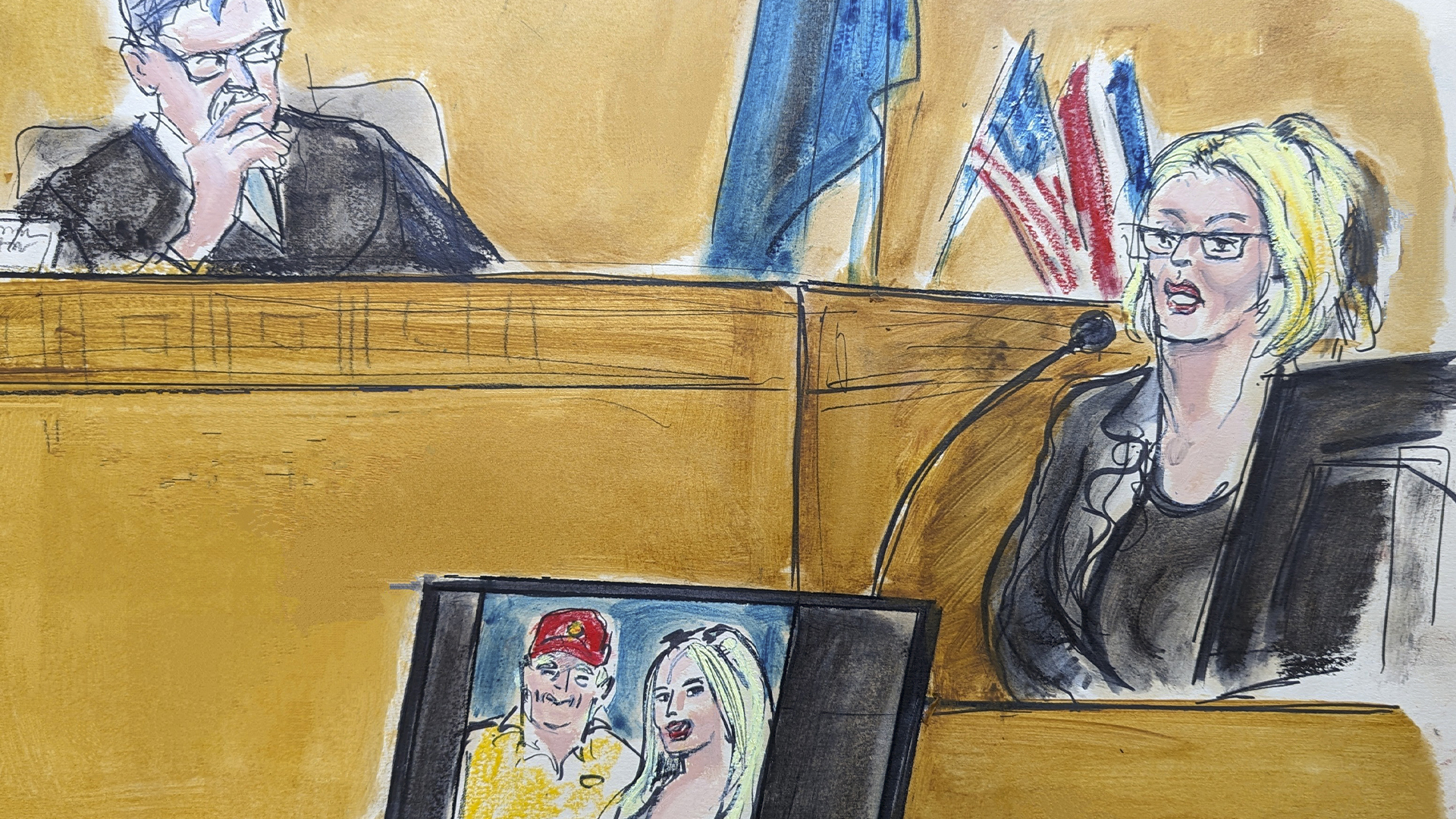 Stormy Daniels témoigne à la barre sous le regard du juge Juan Merchan au tribunal pénal de Manhattan, le mardi 7 mai 2024, à New York. Une photo de Donald Trump et Mme Daniels lors de leur première rencontre est affichée sur un écran. 