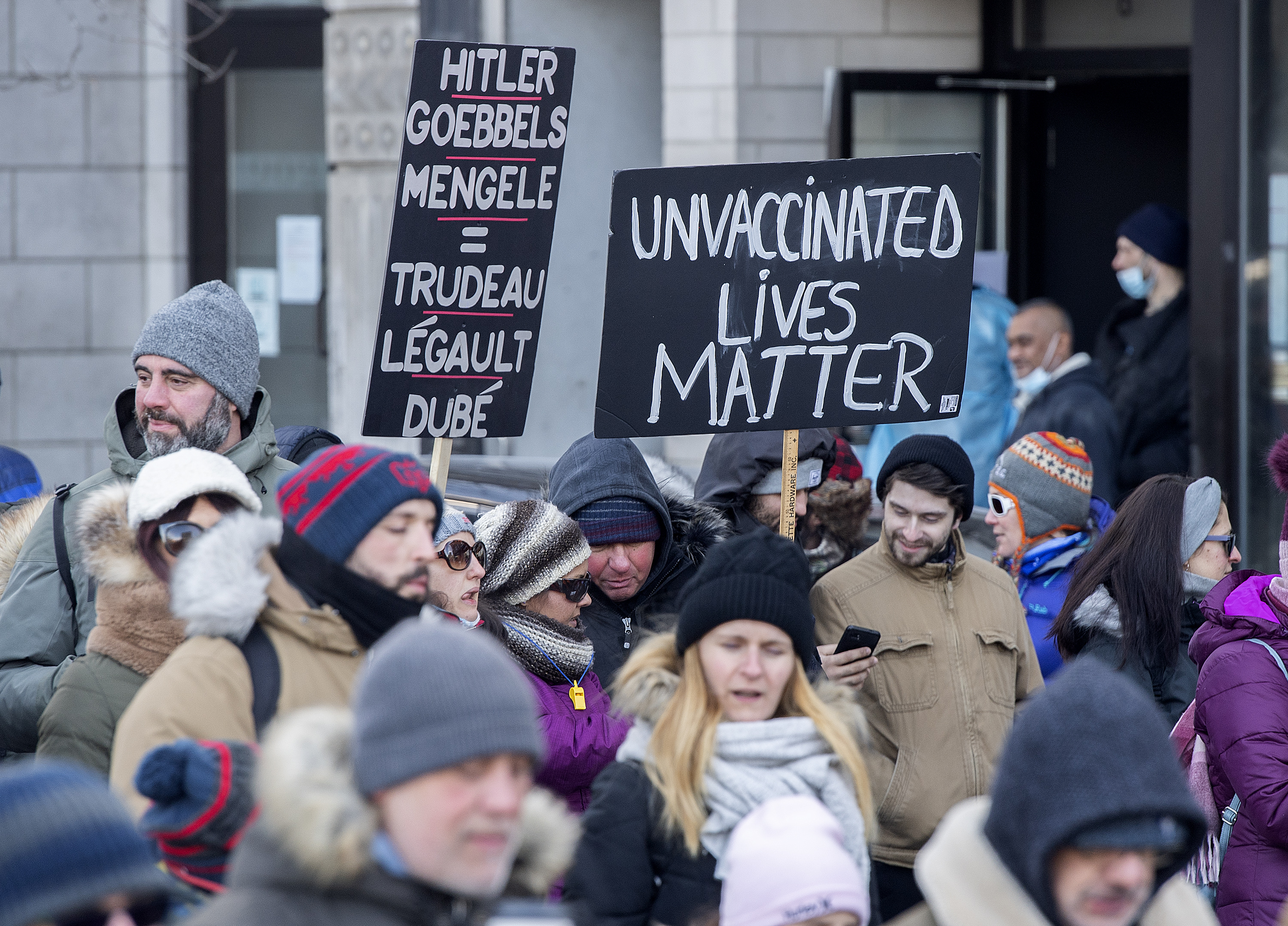 Des gens affichent des messages haineux envers Justin Trudeau, François Legault et Christian Dubé lors de la manifestation anti-mesures sanitaires au Vieux-Port de Montréal.