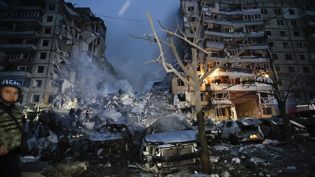 Des secouristes dégagent les décombres après qu'une roquette russe ait frappé un immeuble de plusieurs étages, laissant de nombreuses personnes sous les débris à Dnipro le 14 janvier 2023. 
