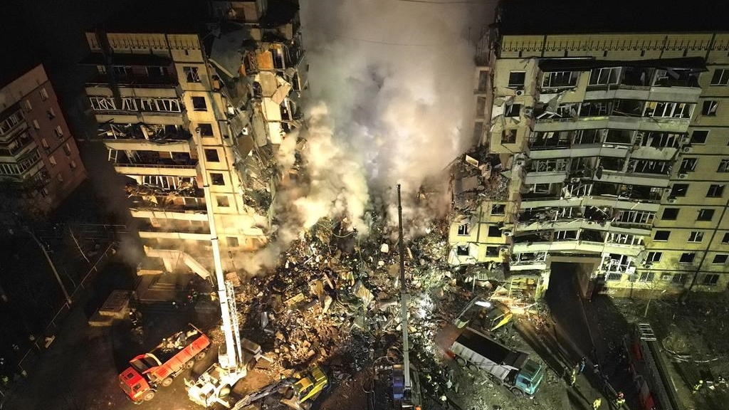 Des secouristes dégagent les décombres après qu'une roquette russe ait frappé un immeuble de plusieurs étages le 14 janvier 2023.