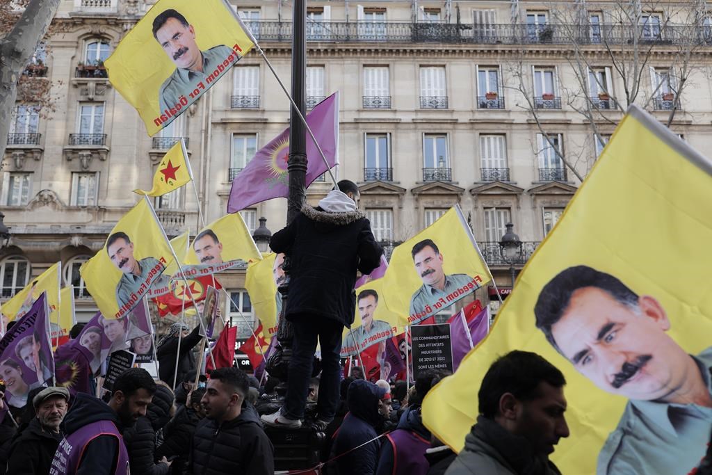 Kurdish activists hold a posters of jailed PKK leader Abdullah Ocalan during a protest in Paris, Saturday, Jan. 7, 2023. Kurdish groups from around France and Europe are marching in Paris to show their anger over the unresolved killing of three Kurdish women activists in the French capital 10 years ago and also mourning three people killed outside a Kurdish cultural center in Paris two weeks ago in what prosecutors called a racist attack. ( AP Photo/Lewis Joly)