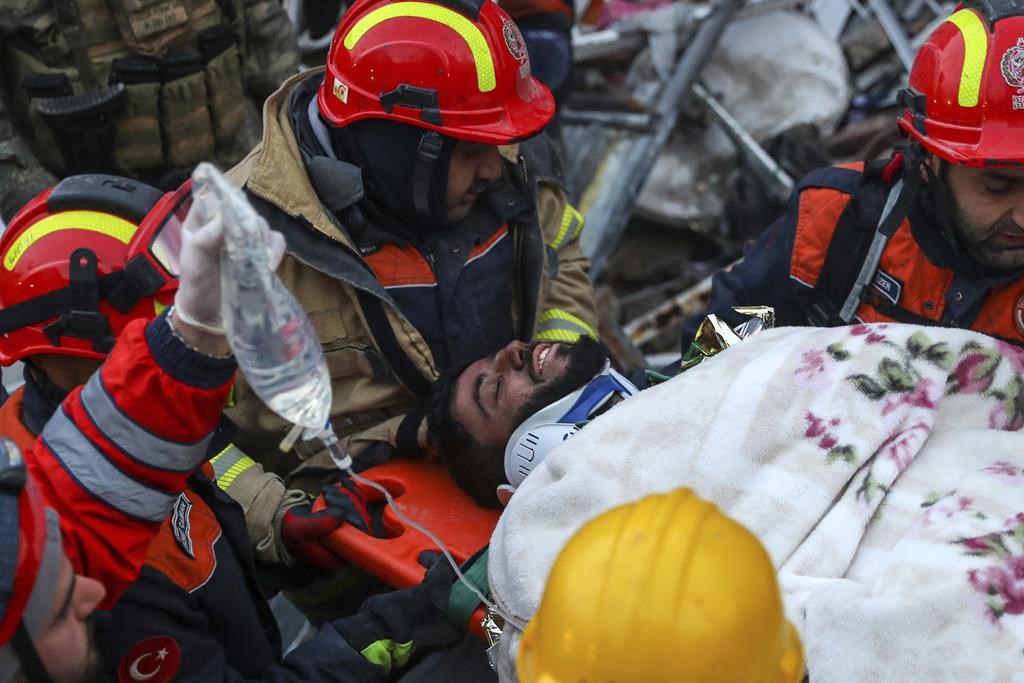 Turkish rescue workers carry Ergin Guzeloglan, 36, to an ambulance after pulled him out from a collapsed building five days after the earthquake, in Hatay, southern Turkey, early Saturday, Feb. 11, 2023. Emergency crews made a series of dramatic rescues in Turkey on Friday, pulling several people, some almost unscathed, from the rubble, four days following a catastrophic earthquake.(AP Photo/Can Ozer)
