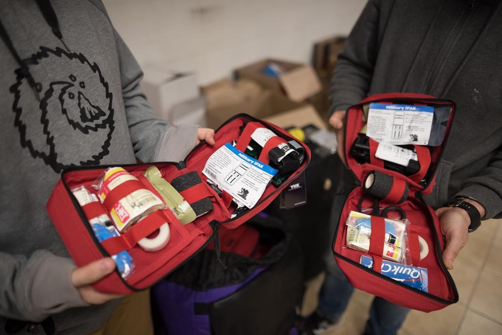 Volunteers with the Second Front Ukraine Foundation hold first aid kits that will be distributed to civilians in Ukraine, at their warehouse in Vaughan, Ont., on Tuesday, March 15, 2022. Ukrainian Canadian organizations working to support those affected by the war in Ukraine say they raised $52 million for aid efforts last year and are calling on Canadians to continue their support as the conflict enters a second year. THE CANADIAN PRESS/ Tijana Martin