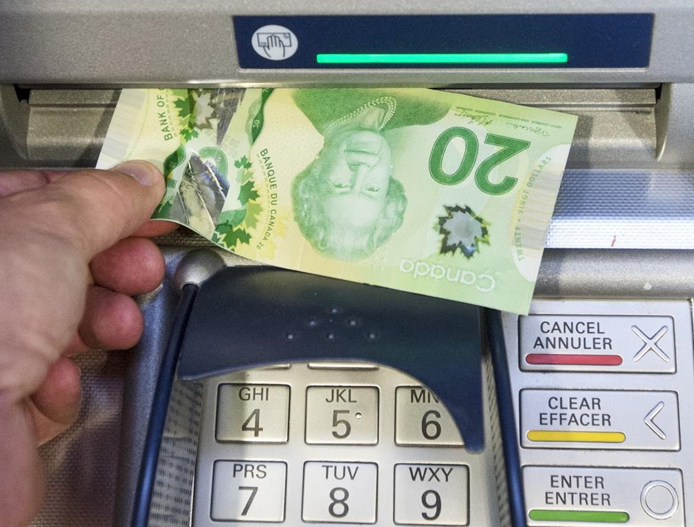 Money is removed from an ATM in Montreal, Monday, May 30, 2016. A new poll finds one-third of Canadian households say their financial situation has worsened over the last year. THE CANADIAN PRESS/Ryan Remiorz