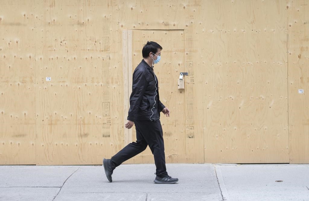 A man walks by a boarded-up storefront in Montreal, Sunday, May 3, 2020. The number of insolvencies filed by Canadian businesses in 2022 was up 37.2 per cent compared with 2021. THE CANADIAN PRESS/Graham Hughes