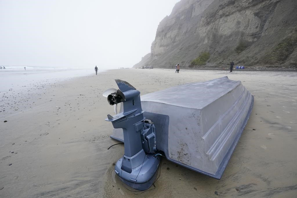 A boat sits overturned on Blacks Beach, Sunday, March 12, 2023, in San Diego. (AP Photo/Gregory Bull)