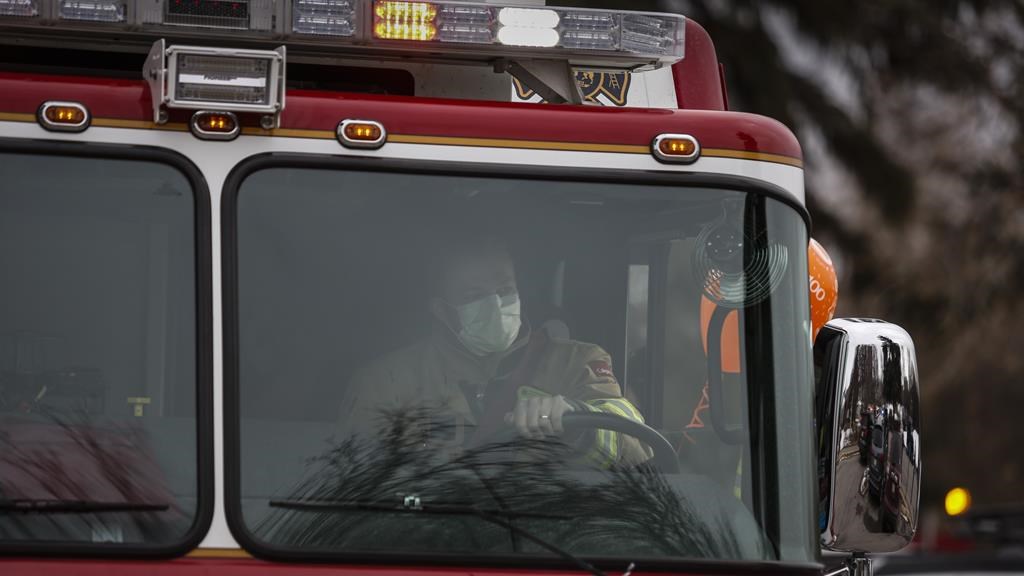 A Calgary Fire Department firefighter drives a fire truck in Calgary, Tuesday, April 14, 2020. A house explosion in northeast Calgary has devastated a neighbourhood and resulted in multiple injuries. THE CANADIAN PRESS/Jeff McIntosh