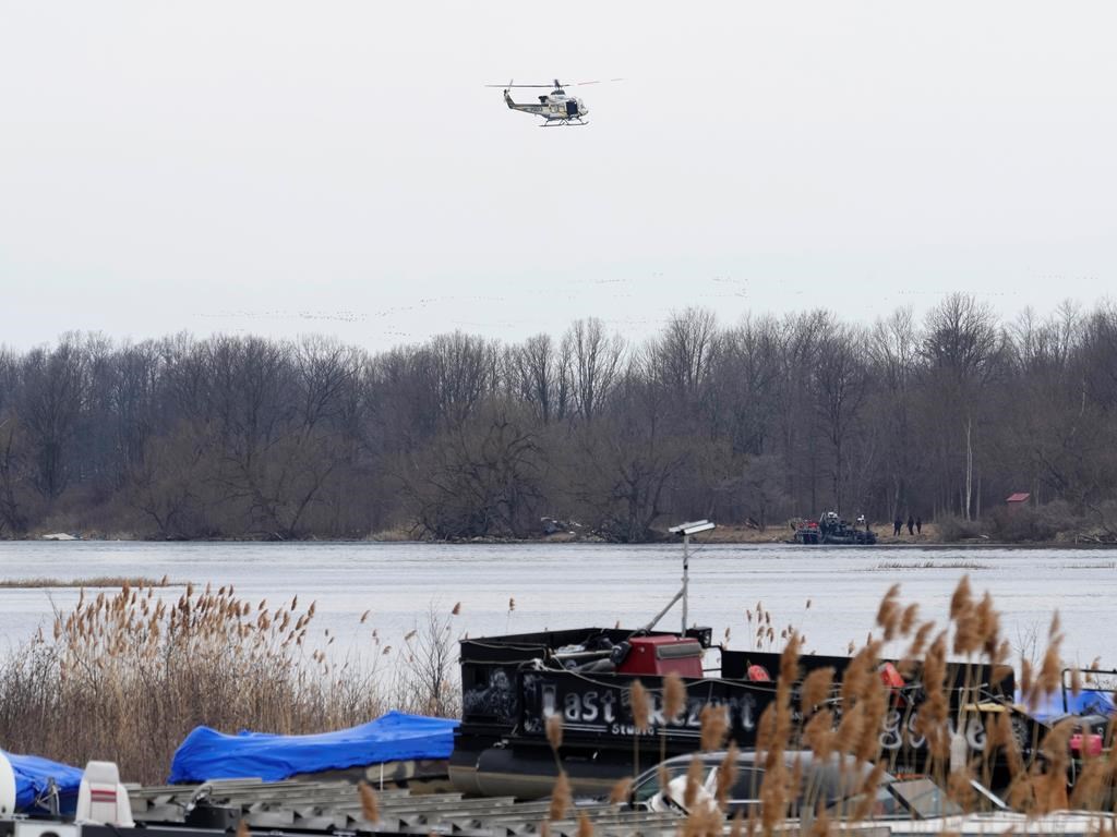 A police helicopter searches the area in Akwesasne, Que., Friday, March 31, 2023. Federal prosecutors in the United States say an Indian man living in Canada was paid thousands of dollars to smuggle other Indian nationals into the U.S. through Akwesasne Mohawk reserve. THE CANADIAN PRESS/Ryan Remiorz