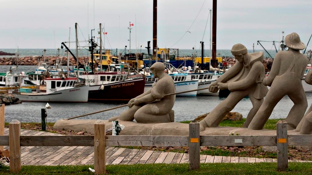 Une sculpture montre des pêcheurs tirant sur une ligne devant la marina, le 6 août 2012, à L'Étang du Nord aux Îles-de-la-Madeleine. 