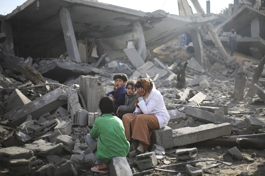 American officials say they are still trying to sort out what caused the Israeli military to detain members of a Canadian-American family in the Gaza Strip. Palestinians sit by the destruction from the Israeli bombardment of the Gaza Strip in Rafah on Monday, Feb. 12, 2024. THE CANADIAN PRESS/AP-Hatem Ali