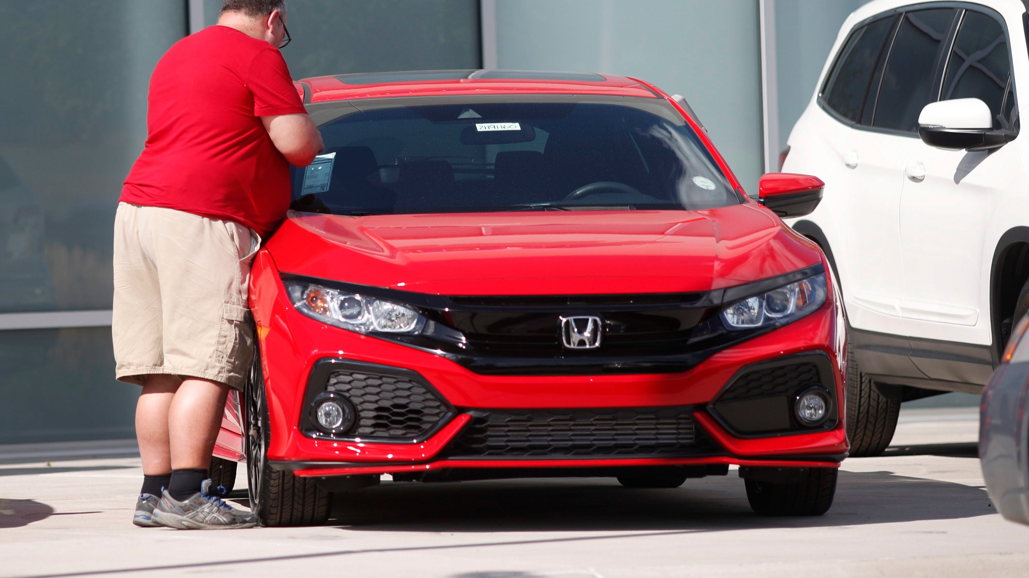 A prospective buyer checks over a 2019 Civic sedan outside a Honda dealership in Highlands Ranch, Colo., on Aug. 25, 2019. (David Zalubowski / AP Photo)