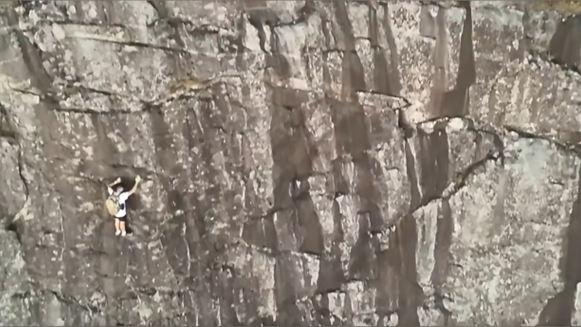 A climber, shown in a video screengrab, hangs onto the side of Mount Yonah in northern Georgia on Aug. 25, 2026. (White County Public Safety)