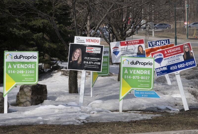 Des panneaux «À vendre» pour des condos sont visibles à Deux-Montagnes, dans les Laurentides, le mercredi 29 mars 2023.