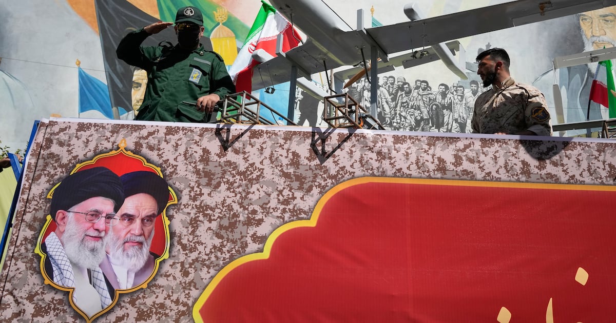 Photo: noovo.info Un membre des Gardiens de la Révolution iranienne salue depuis un char sur lequel sont exposés des drones, lors du défilé de